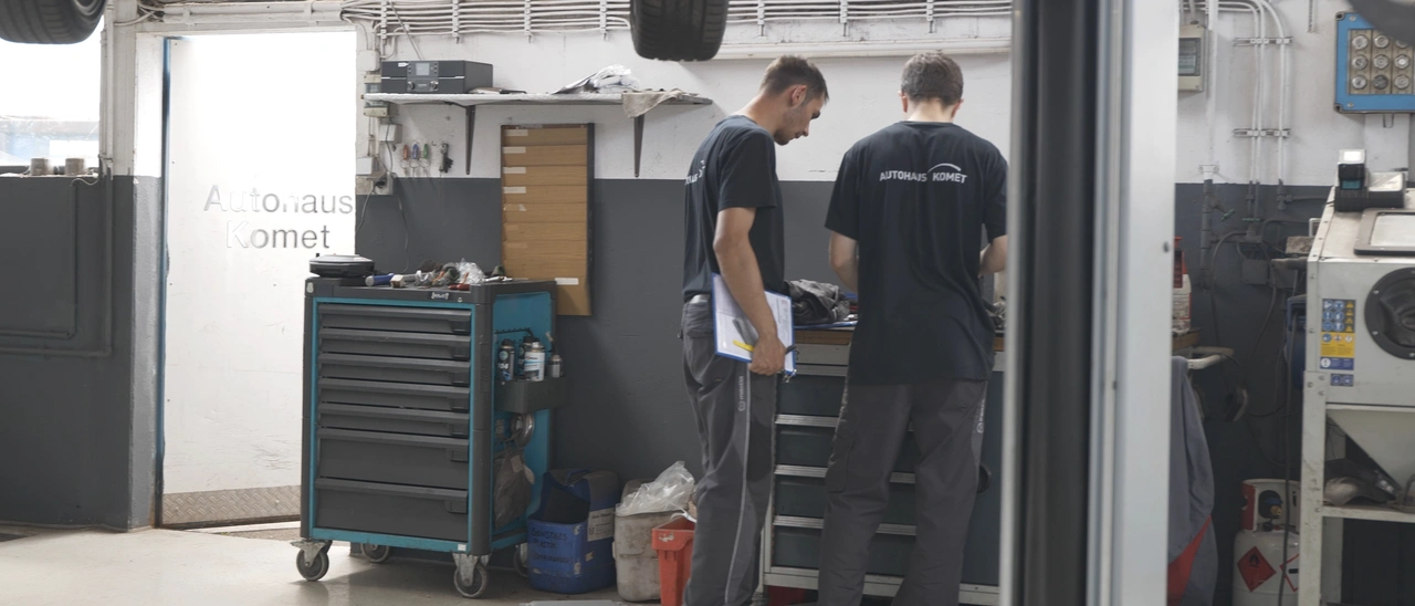 Zwei Mechaniker des Autohauses Komet am Werkzeugwagen in der Werkstatt