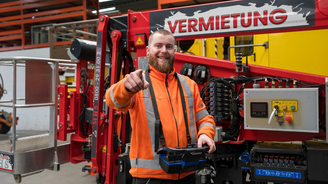 Servicetechniker von B.O.E. TECHNIK zeigt auf die Steuerung eines Arbeitsfahrzeugs