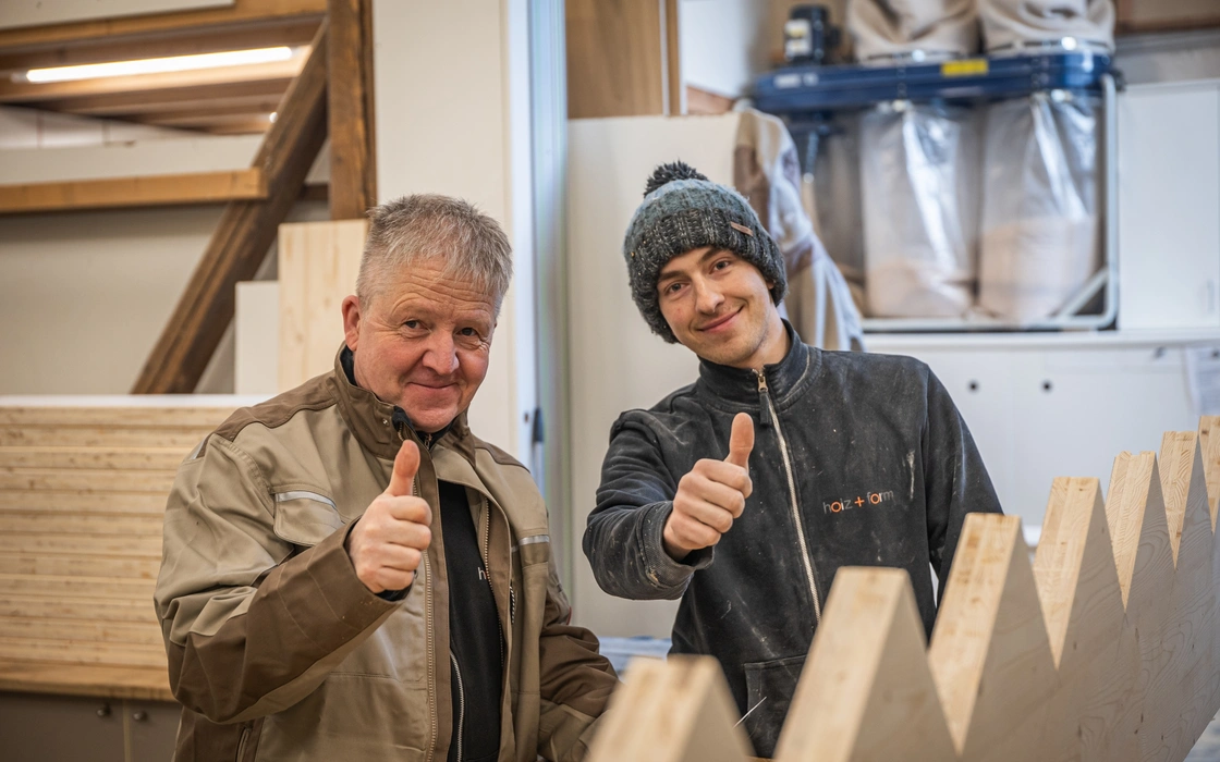 Zwei Holzhandwerker mit Werkstücken