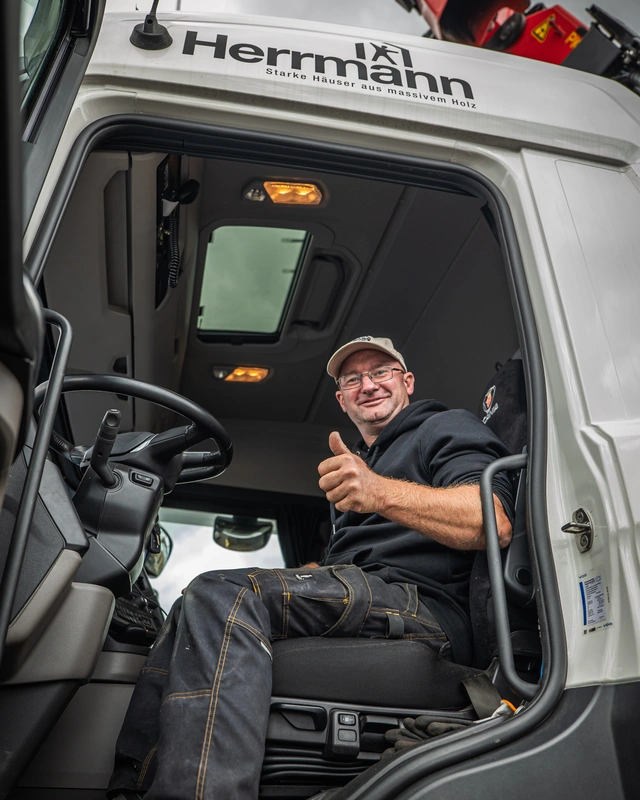 Lkw-Fahrer sitzt im Fahrerhaus und hebt den Daumen