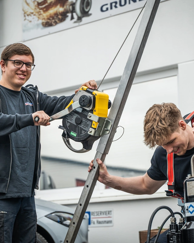 Techniker an einer Pumpenanlage mit Hebezeug
